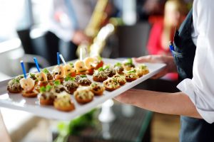 Waiter carrying plates with meat dish on some festive event, party or wedding reception